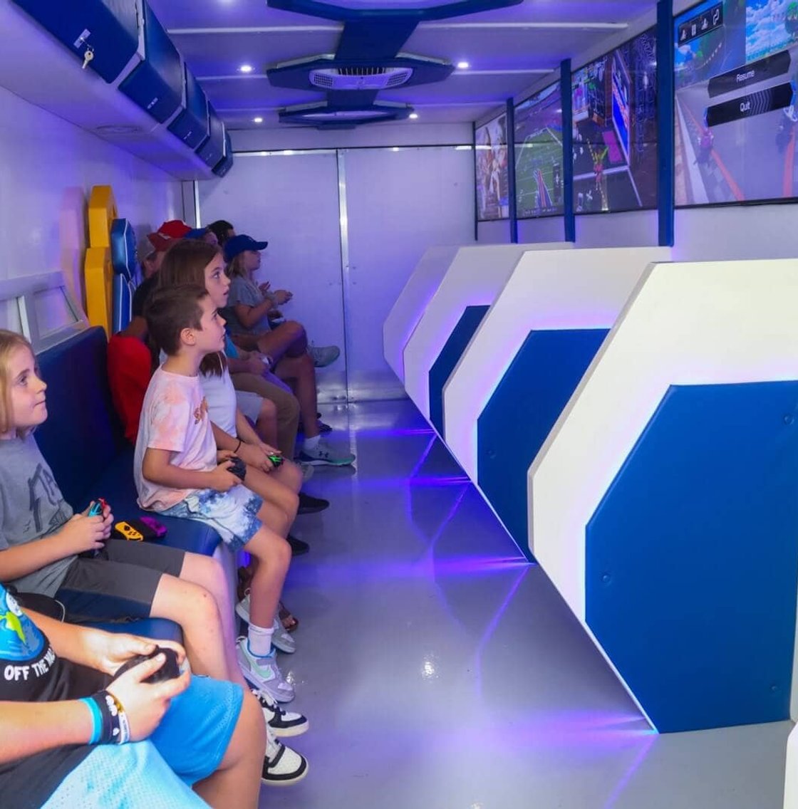 Kids playing video games inside mobile gaming trailer