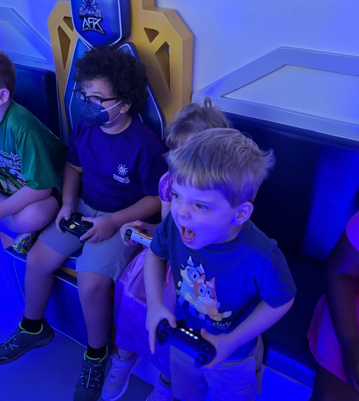 Excited young boy with open mouth holding controller